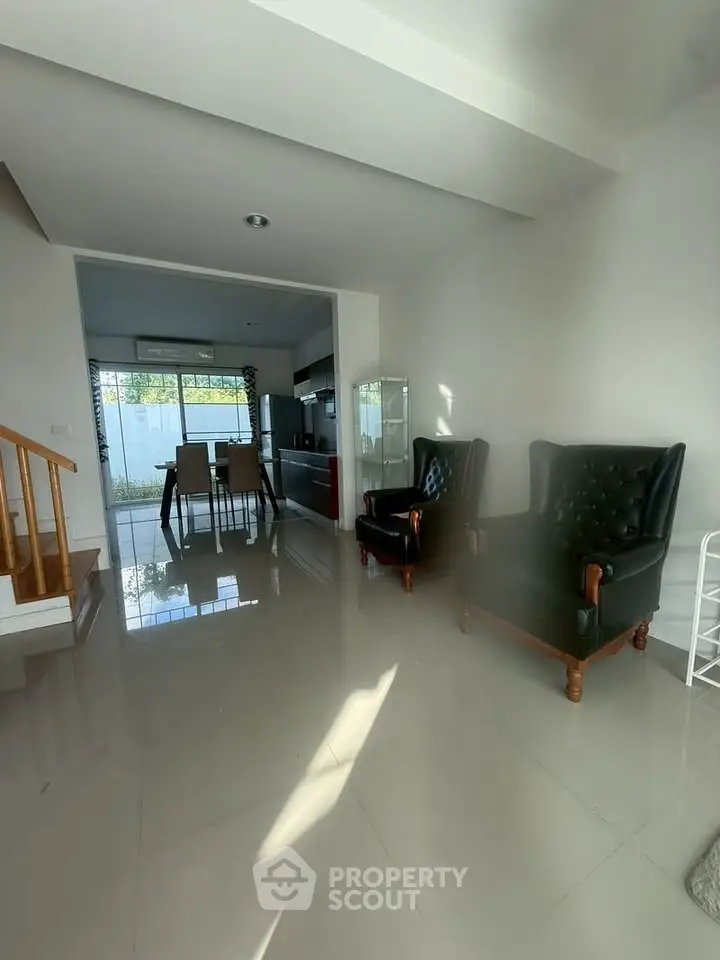 Spacious living room with elegant chairs and open view to dining area, perfect for modern living.
