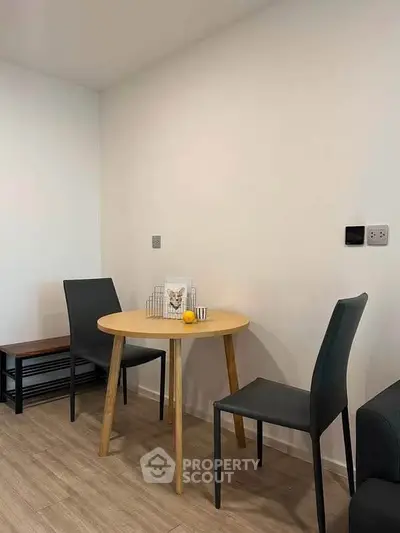 Cozy dining nook with modern chairs and round table in minimalist apartment.