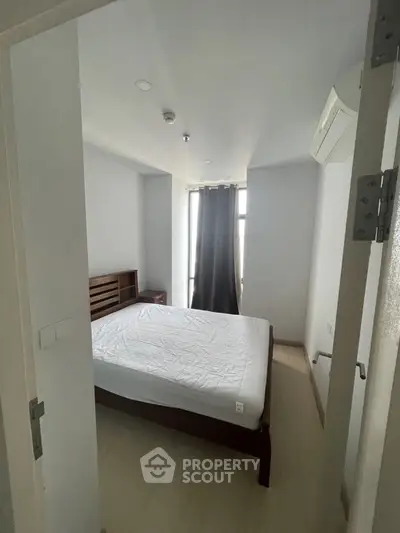 Cozy bedroom with natural light and modern furnishings in a stylish apartment.