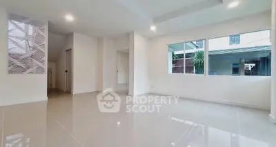 Spacious modern living room with large windows and glossy tiled floors