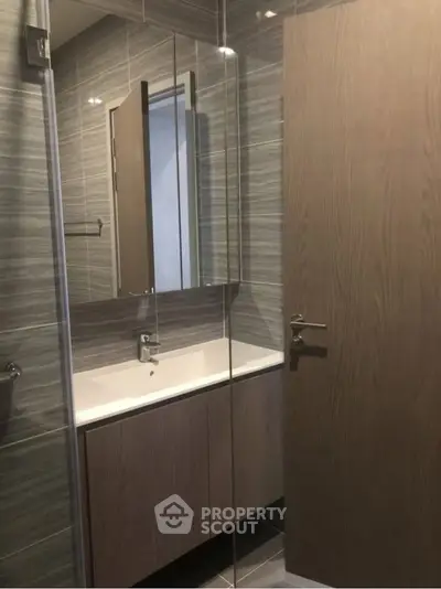 Modern bathroom with sleek vanity and mirror in stylish apartment.