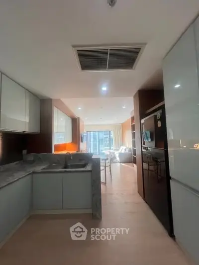 Modern kitchen with sleek design and open layout leading to a bright living area.