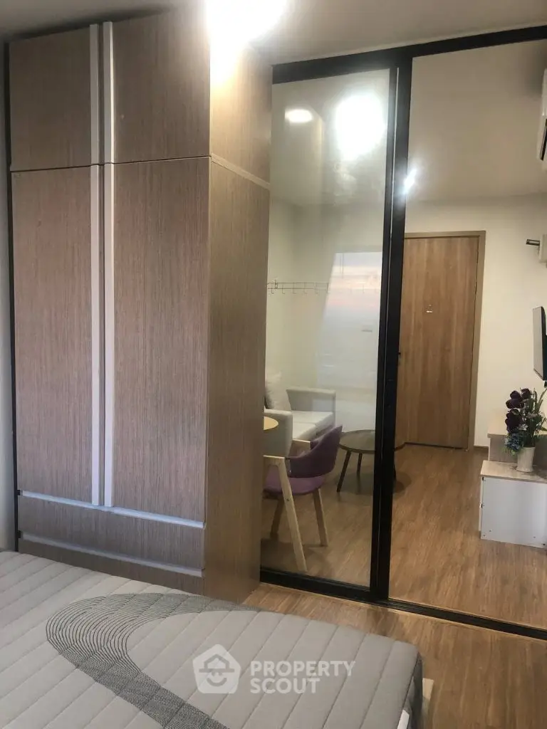Modern apartment interior with stylish furniture and wooden flooring, featuring a cozy living area and sleek wardrobe.