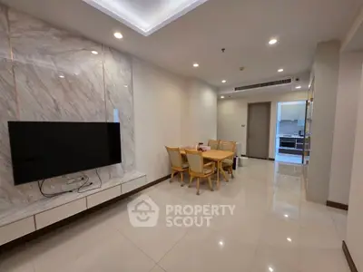 Spacious modern living room with marble accent wall and dining area in open layout apartment.