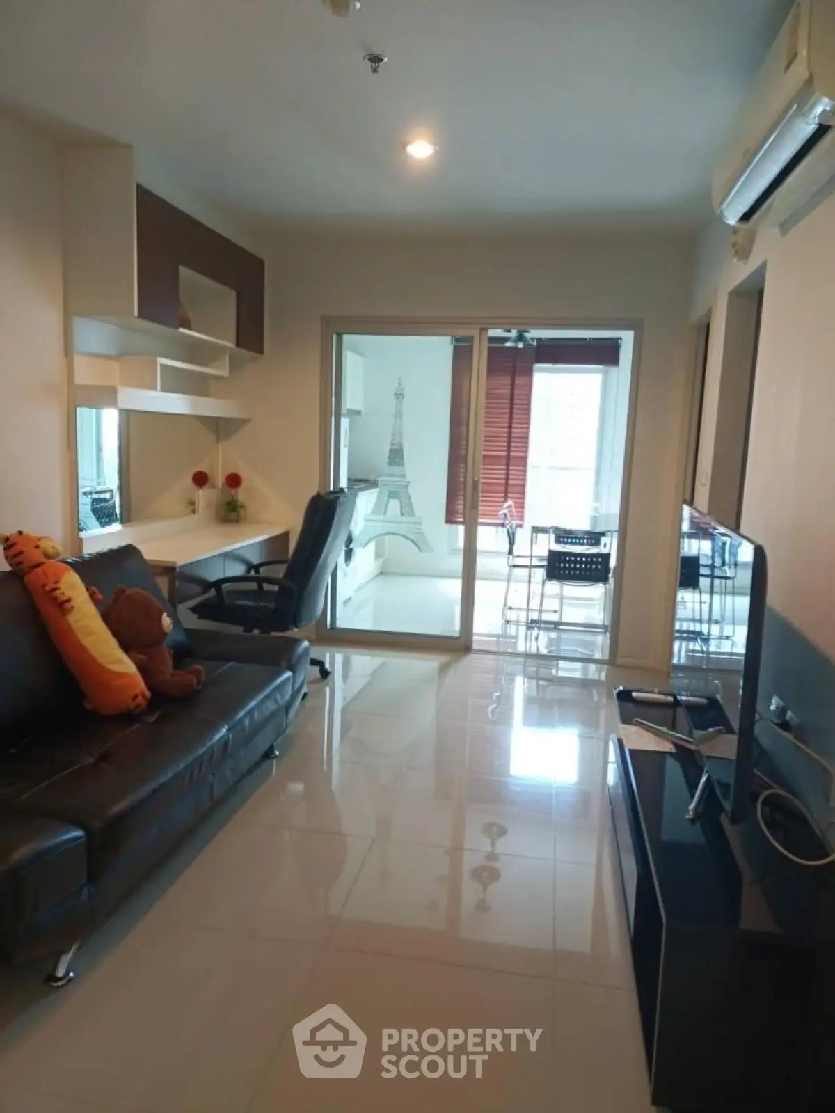 Modern living room with sleek furniture and Eiffel Tower wall art, featuring a cozy study nook.