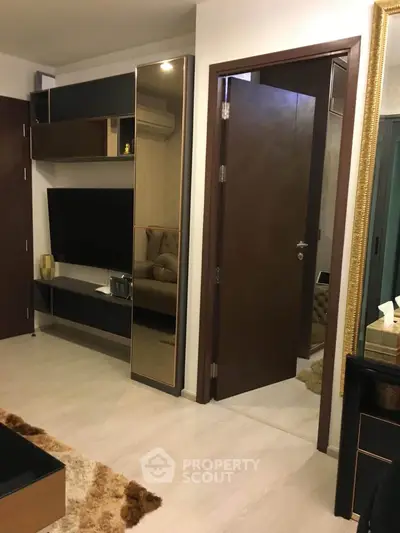 Modern living room with stylish decor and open doorway, featuring sleek furniture and elegant design.