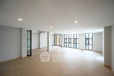 Spacious modern living room with large windows and wooden flooring