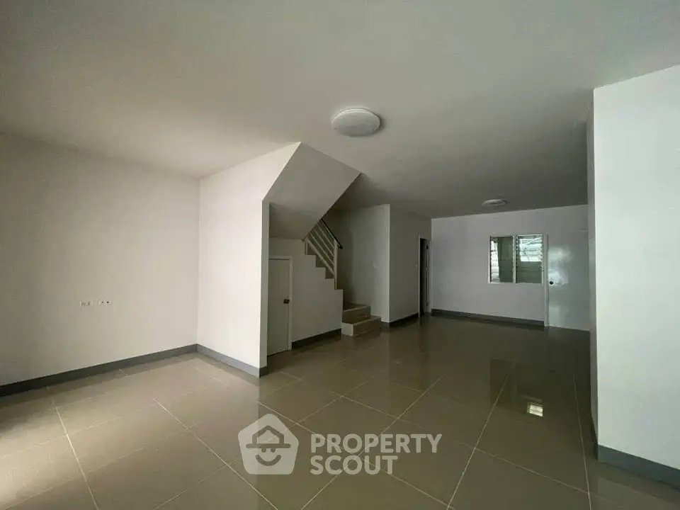 Spacious modern interior with staircase and tiled flooring, ideal for customization.