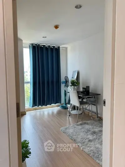 Modern study room with desk, chair, and large window with blue curtains.