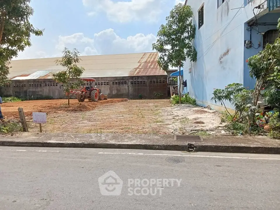 Vacant land plot with adjacent building, ideal for development opportunities.