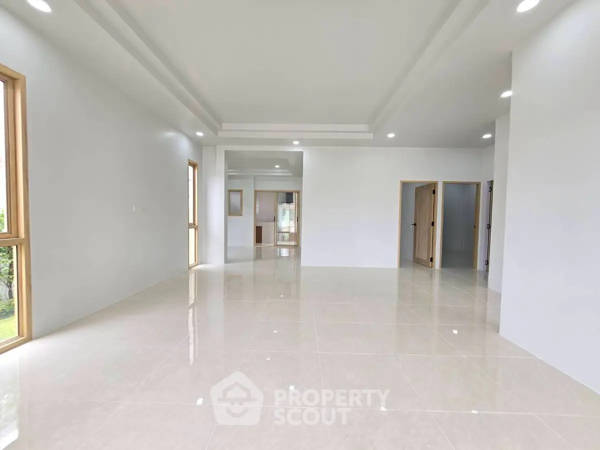 Spacious modern living room with glossy tiled floors and large windows for natural light.