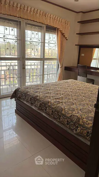 Spacious bedroom with large windows and elegant decor