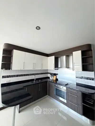 Modern kitchen with sleek cabinetry and built-in oven in a stylish apartment.