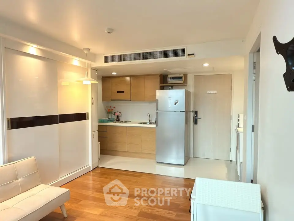 Modern studio apartment with open kitchen and sleek wooden flooring