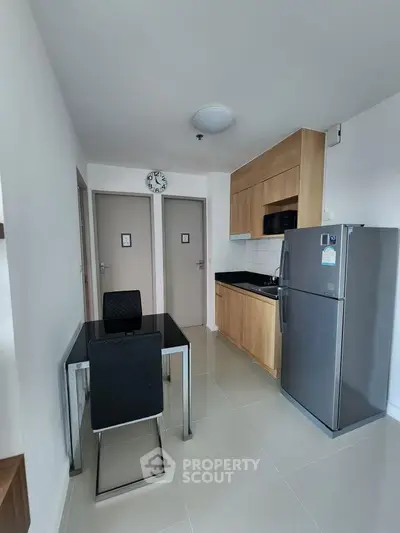 Modern compact kitchen with sleek appliances and dining area in a stylish apartment