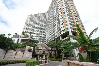 Modern high-rise condominium with lush greenery and secure entrance