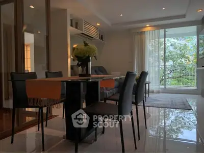 Elegant dining area with modern furniture and large windows offering a serene garden view.
