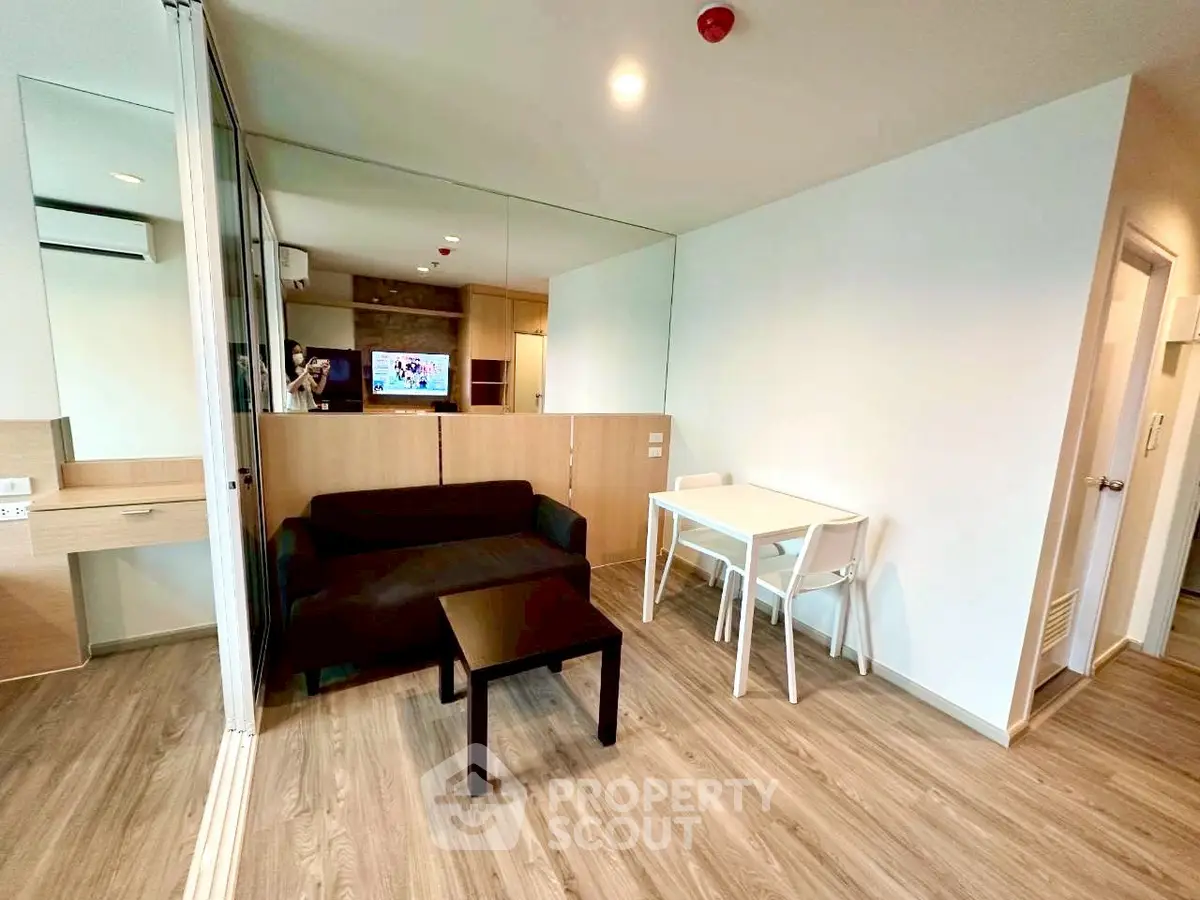 Modern living room with sleek wooden flooring and minimalist furniture in a stylish apartment.