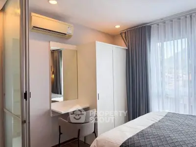 Cozy bedroom with modern decor, featuring a large window and stylish furniture.