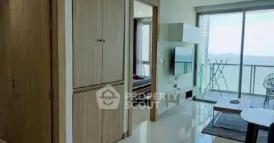 Modern apartment with ocean view, spacious living room, and stylish balcony.