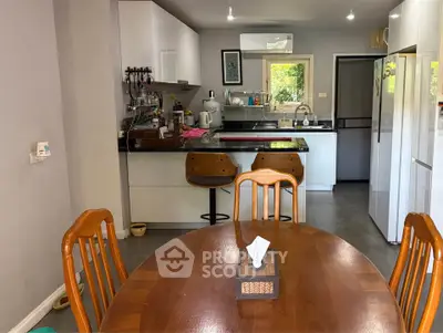 Charming kitchen with open layout and dining area, featuring modern appliances and cozy seating.