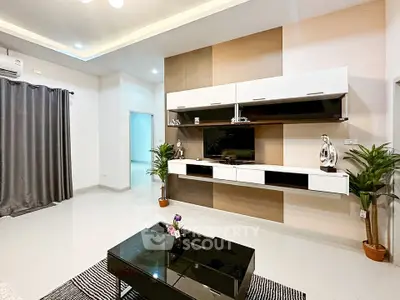 Modern living room with sleek furniture and stylish decor, featuring a wall-mounted TV and elegant shelving.