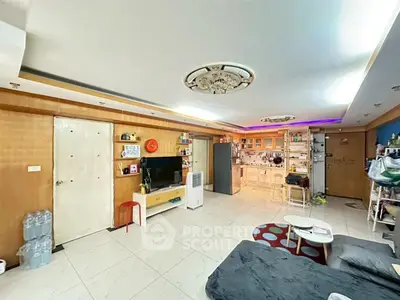 Spacious living room with modern kitchen in open layout, featuring stylish decor and ample natural light.