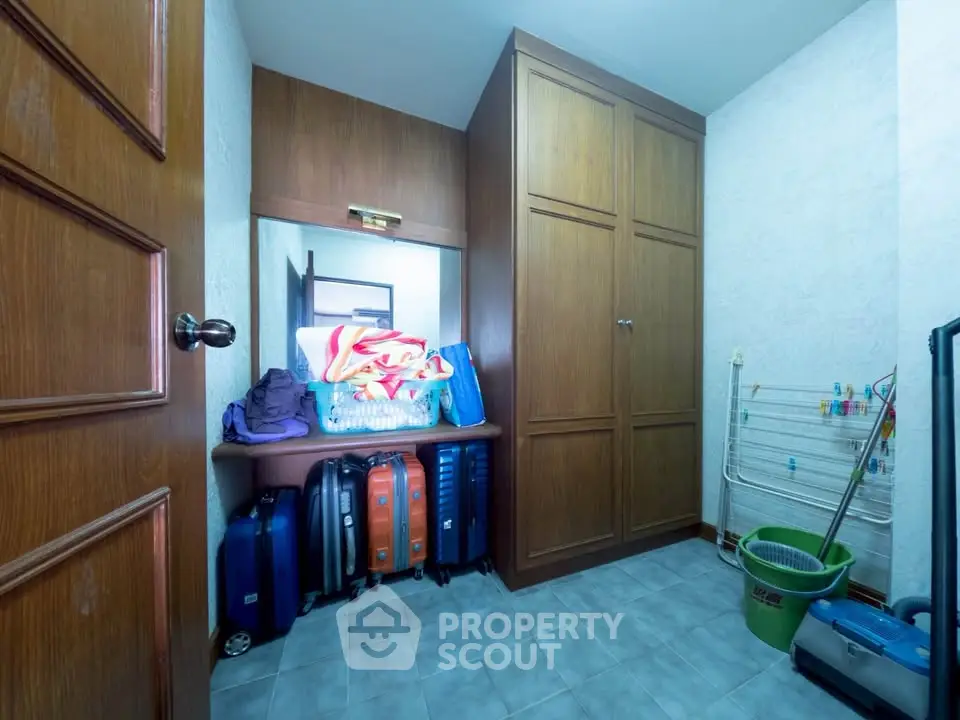 Cozy storage room with ample wooden cabinetry and organized luggage space.