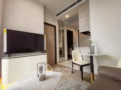 Modern living room with sleek furniture and large TV in a stylish apartment.