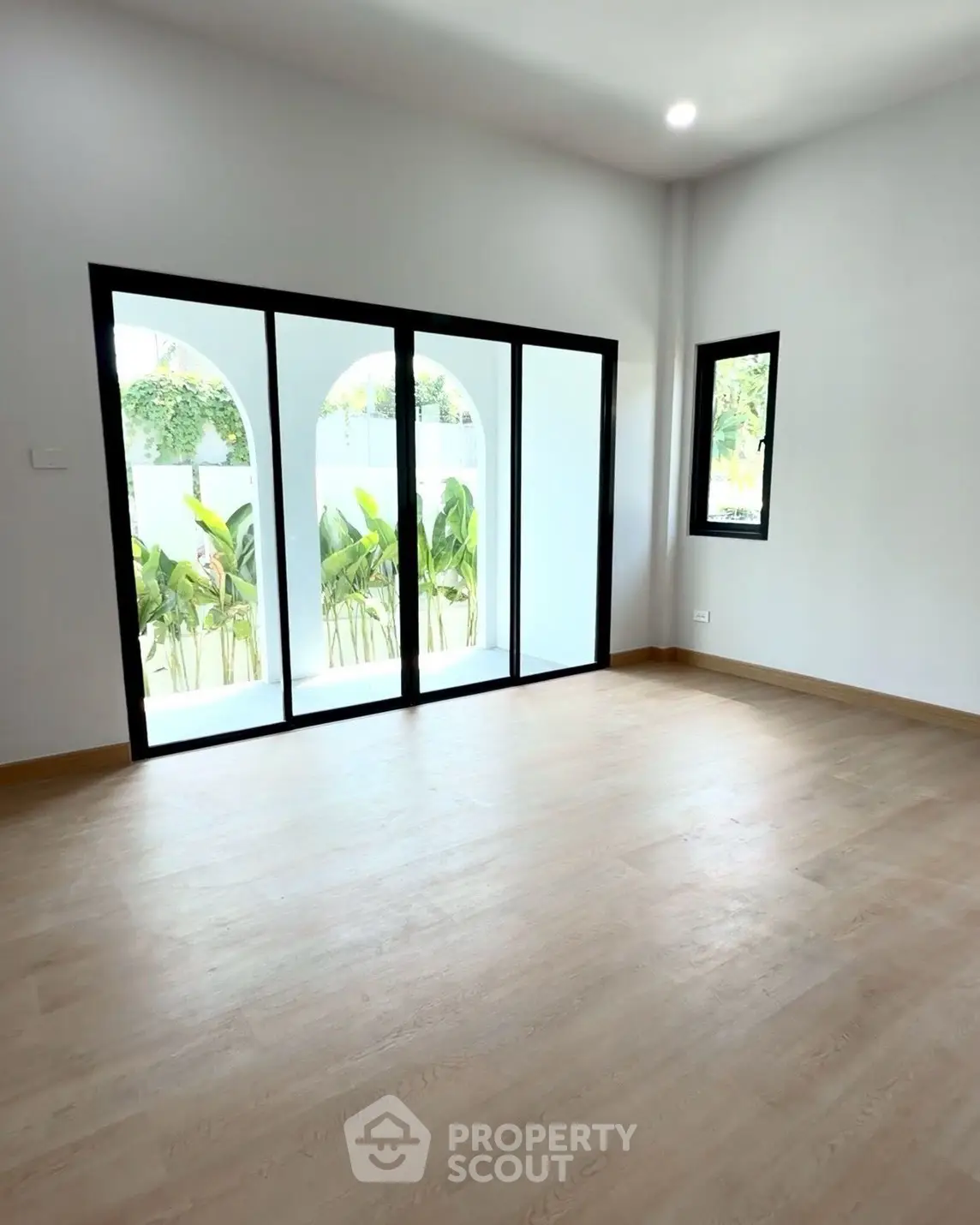 Spacious room with large windows and garden view, perfect for modern living.