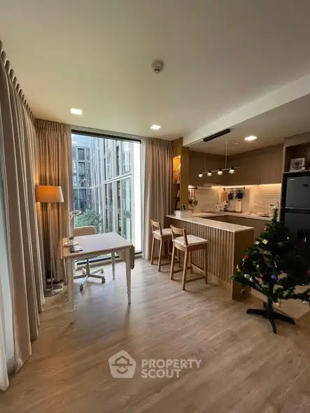 Modern open-plan living room with kitchen and large windows in a stylish apartment.