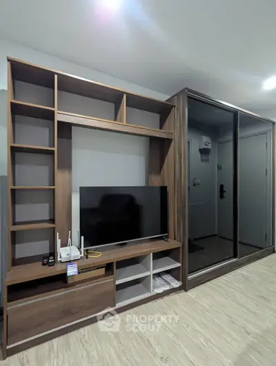 Modern living room with sleek wooden entertainment center and mirrored wardrobe