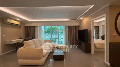 Spacious living room with modern decor and large windows leading to a balcony.