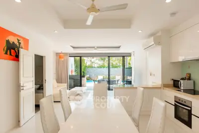 Spacious open-plan kitchen and living area with modern decor and pool view.