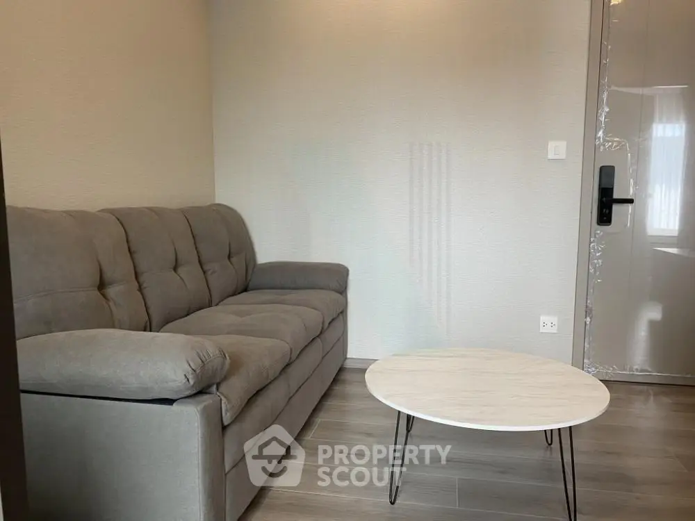 Cozy living room with modern gray sofa and stylish round coffee table.