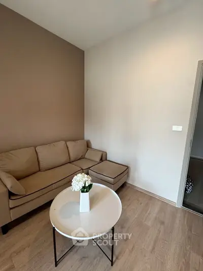 Cozy living room with beige sofa and modern round coffee table, perfect for relaxation.