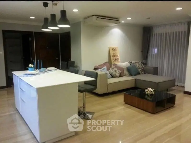 Modern open-layout living room with stylish kitchen island and cozy seating area.