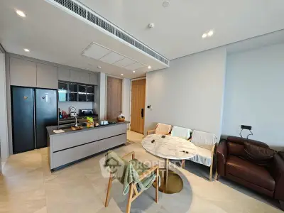 Modern open-layout kitchen and living area with sleek design and cozy seating.