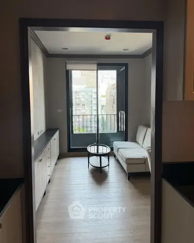 Modern living room with large window and city view, featuring a cozy sofa and stylish coffee table.