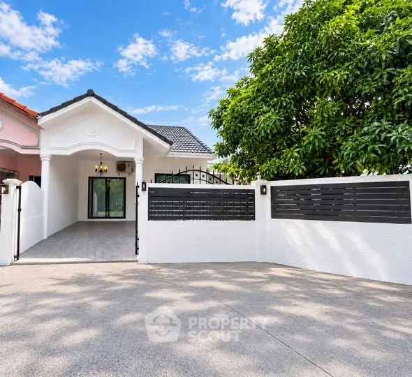 Charming single-story home with gated entrance and lush greenery