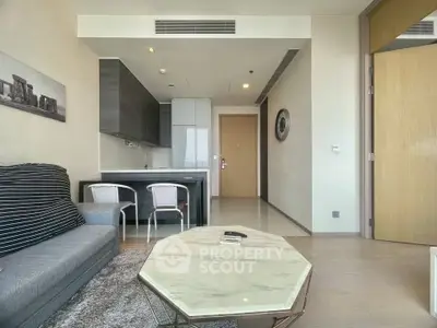 Modern living room with open kitchen, stylish furniture, and elegant decor in a contemporary apartment.