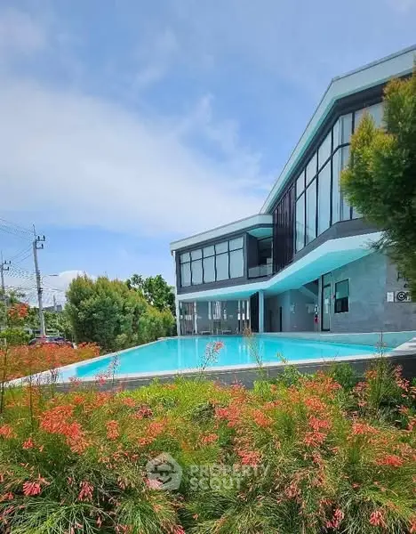 Modern architectural home with sleek design and inviting pool surrounded by lush greenery.
