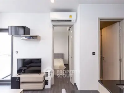 Modern apartment interior with sleek living room and bedroom view, featuring stylish furniture and air conditioning.