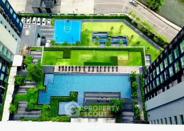Luxurious aerial view of modern condominium with pool, garden, and sports court, perfect for urban living.