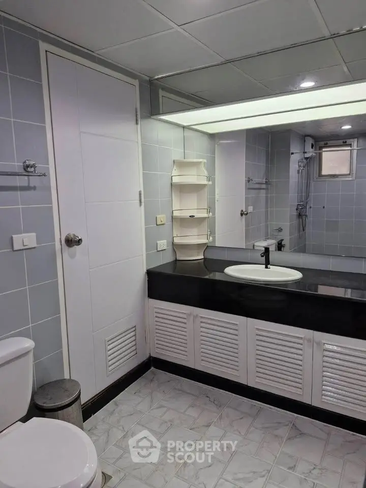 Modern bathroom with sleek fixtures and large mirror in a stylish real estate property.