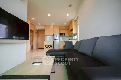 Modern living room with sleek black sofa and open kitchen layout