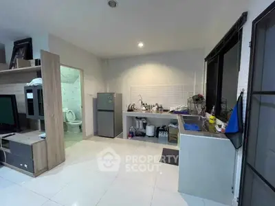 Modern kitchen with open layout and adjacent bathroom in a cozy apartment.