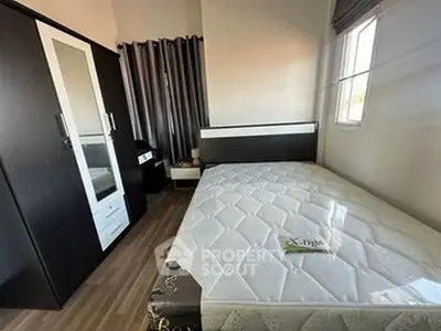 Modern bedroom with sleek furniture and large window for natural light.