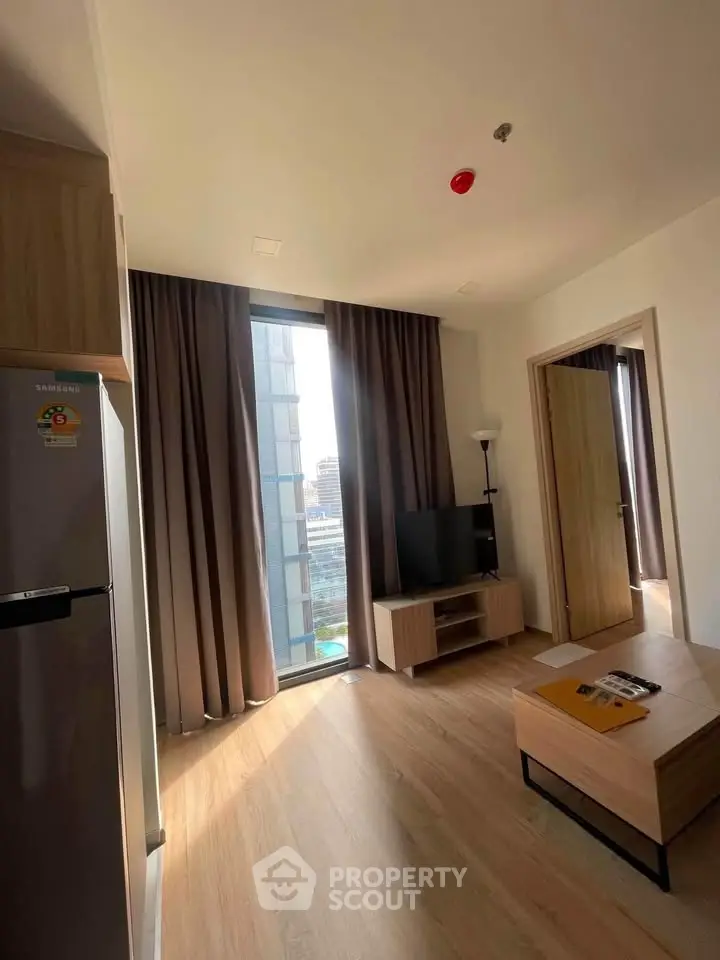 Modern living room with large window and stylish furniture in a high-rise apartment.