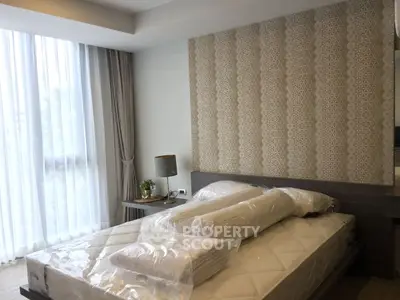 Elegant bedroom with modern decor and large window, featuring a stylish bed and ambient lighting.